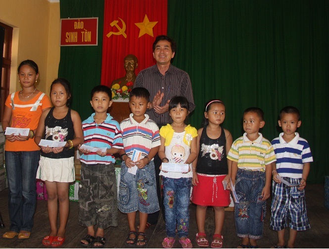 Đồng chí Trần Thanh Khê, Ủy viên Ban Thường vụ, Trưởng Ban Tuyên giáo Đảng ủy Khối, Phó Trưởng đoàn công tác tặng thẻ bảo hiểm cho các cháu học sinh trên Huyện Đảo Trường Sa