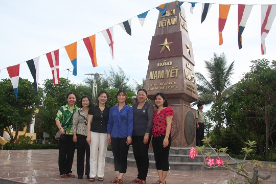 Các nữ đại biểu chụp ảnh lưu niệm trước cột mốc chủ quyền trên đảo Nam Yết. Ảnh: B.T