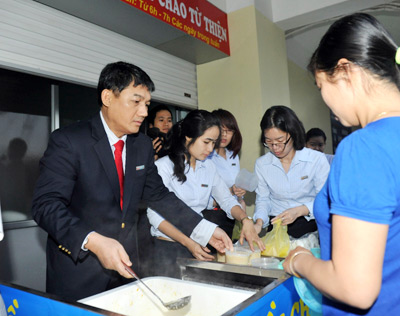 Chủ tịch HĐQT VietinBank Phạm Huy Hùng trực tiếp phát cháo cho người nhà bệnh nhân. 