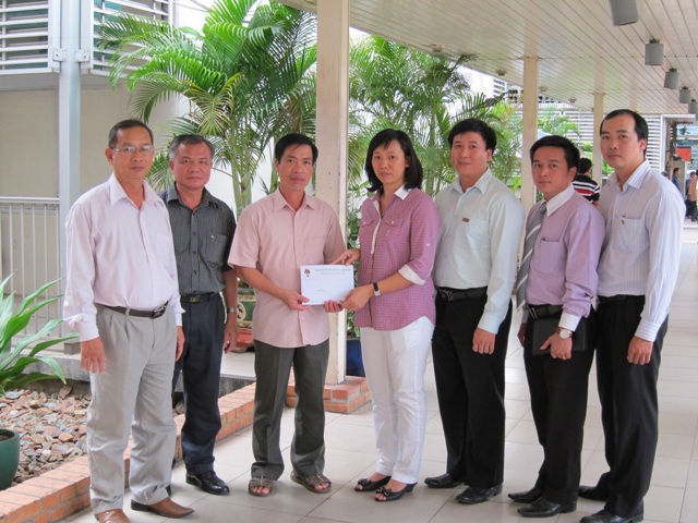 Đồng chí Nguyễn Đầy, Phó Chánh Văn phòng Đảng ủy Khối và đồng chí Trương Thị Huế Minh, Ủy viên BTV Đoàn Khối, Bí thư Đoàn Tập đoàn Công nghiệp Cao su Việt Nam trao  số tiền 27 triệu đồng cho gia đình Đại tá Nguyễn Viết Thuân