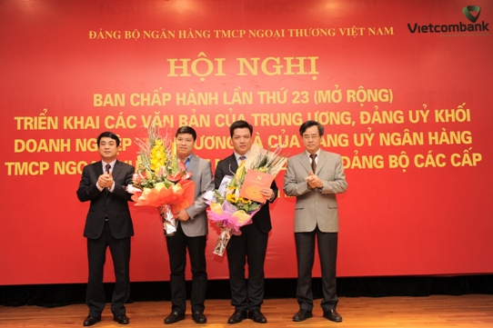 Đ/c Nguyễn Quang Dương - Phó Bí thư ĐUK DNTW (ngoài cùng bên phải) và đ/c Nghiêm Xuân Thành - Ủy viên BCH Đảng bộ Khối DNTW, Bí thư Đảng ủy, Chủ tịch HĐQT (ngoài cùng bên trái) trao quyết định của ĐUK và tặng hoa chúc mừng các đ/c được chỉ định bổ sung tham gia BCH, BTV Đảng ủy Vietcombank nhiệm kỳ 2010 - 2015