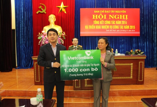 Đại diện Vietcombank, Đ/c Nghiêm Xuân Thành - Bí thư Đảng ủy - Chủ tịch Hội đồng quản trị Vietcombank (bên trái)  trao tặng hộ nghèo tại 10 huyện miền núi giáp Tây Nguyên 1.000 con bò (tương đương 15 tỷ đồng)