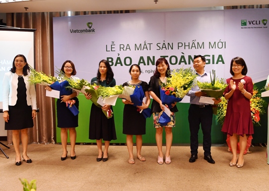 Đại diện Vietcombank và VCLI tặng hoa chúc mừng các khách hàng tham gia sản phẩm Bảo An Toàn Gia