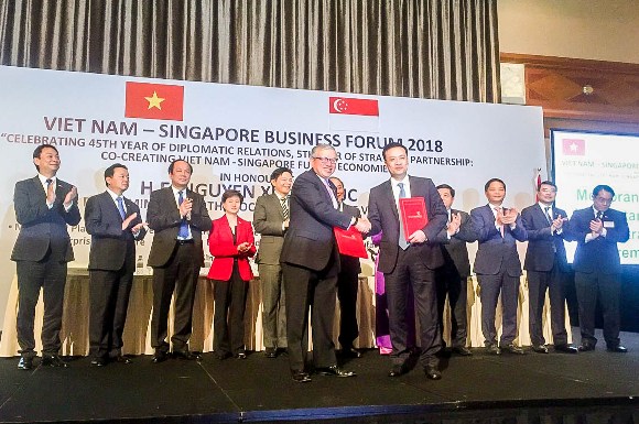 Đại diện Vietcombank, Ông Phạm Quang Dũng – Tổng Giám đốc (hàng đầu, bên phải) và đại diện SBF, ông Ho Meng Kit – Giám đốc điều hành ký kết thỏa thuận hợp tác giữa hai bên