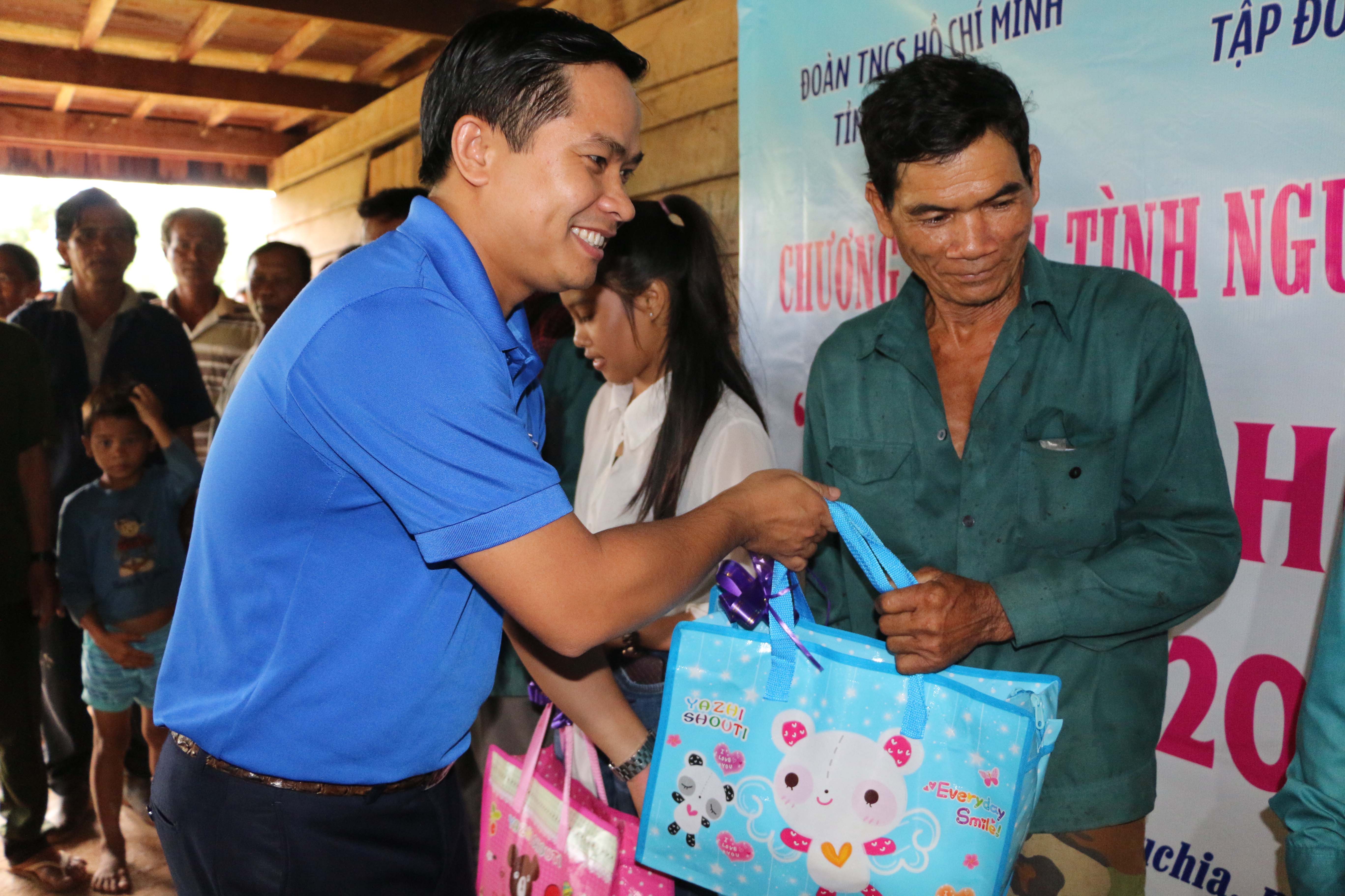 Đồng chí Thái Bảo Tri, UV BCH TW Đoàn, Bí thư ĐTN VRG tặng quà cho con công nhân cao su tại Kratie