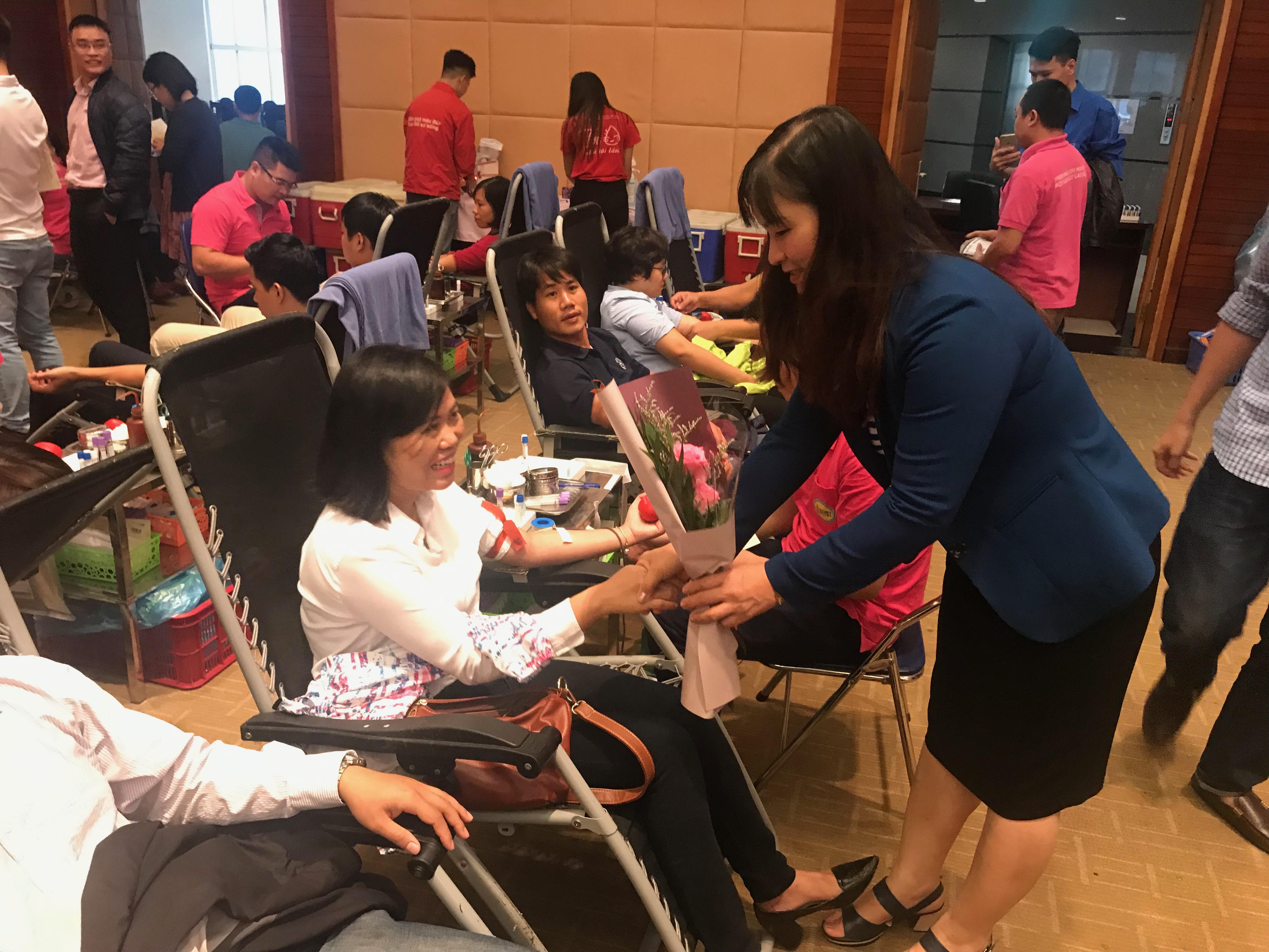 Đồng chí Nguyễn Thị Tiếp, Ủy viên Ban Thường vụ, Trưởng Ban Dân vận Đảng ủy Khối tặng hoa động viên các bạn đoàn viên thanh niên tham gia hiến máu
