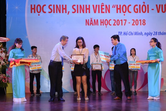 Đại diện lãnh đạo Tập đoàn CN Cao su Việt Nam trao phần thưởng cho các học sinh vượt khó