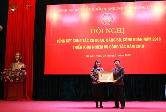 Đồng chí Phạm Tấn Công - Phó Bí thư Thường trực Đảng ủy Khối trao tặng Huân chương Lao động hạng Nhì cho đồng chí Nguyễn Thị Tiếp.