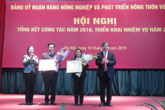 Đại diện lãnh đạo Đảng ủy Khối Doanh nghiệp Trung ương và Đảng ủy Agribank trao tặng Huy hiệu 30 năm tuổi Đảng cho 2 đảng viên.