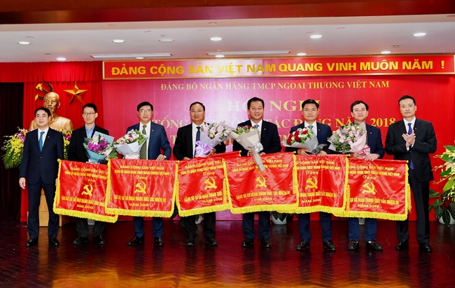 Đ/c Nghiêm Xuân Thành - Ủy viên BCH Đảng bộ Khối Doanh nghiệp Trung ương, Bí thư Đảng ủy, Chủ tịch HĐQT (bên trái) và đ/c Phạm Quang Dũng - Phó Bí thư Đảng ủy, Ủy viên HĐQT, Tổng giám đốc (bên phải) trao Cờ và tặng hoa cho 06 tổ chức Đảng hoàn thành xuất sắc nhiệm vụ năm 2018