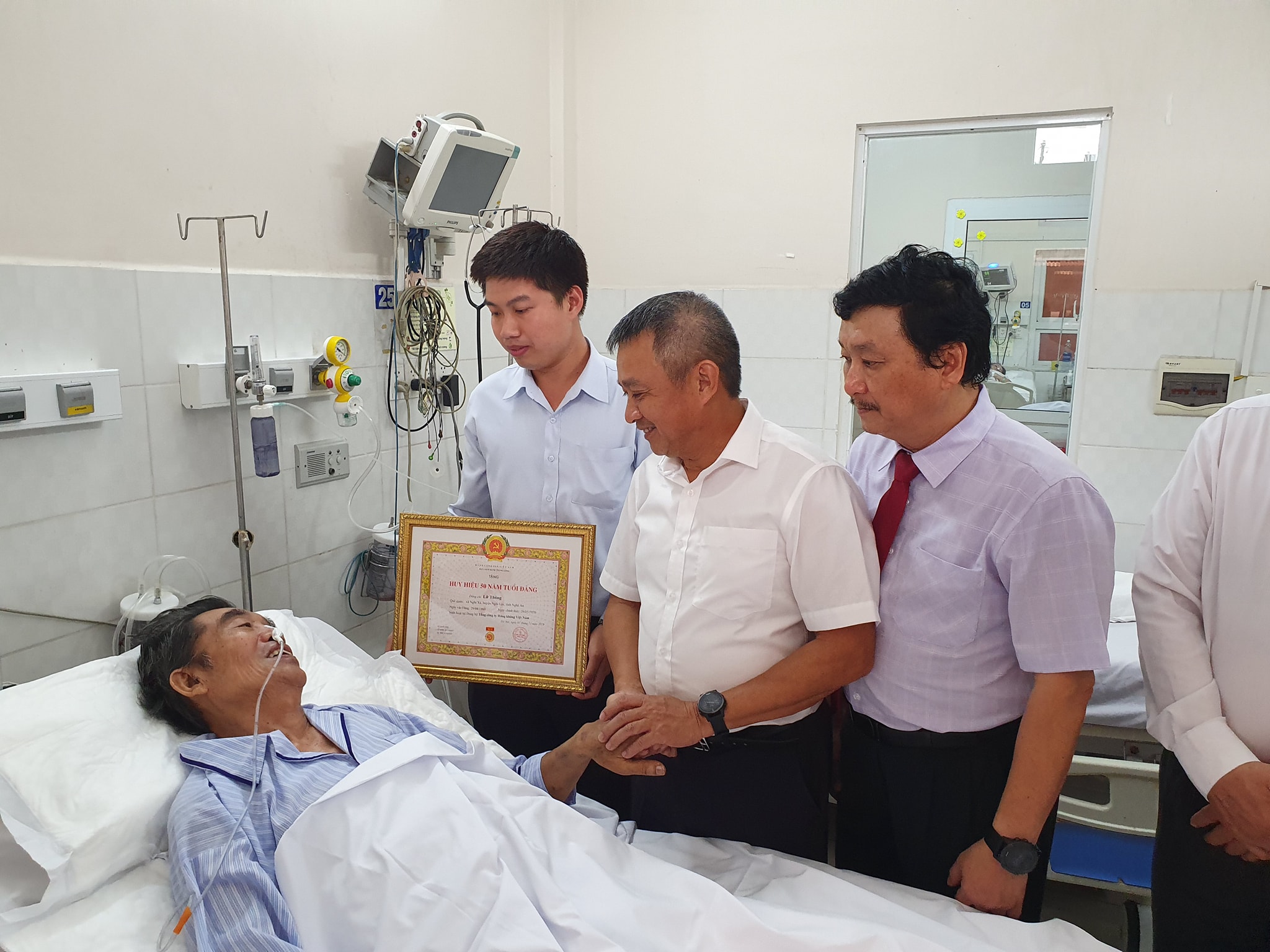 Bí thư Đảng ủy TCT - TGĐ Dương Trí Thành cùng đoàn đại diện Đảng ủy TCT trao tặng huy hiệu 50 năm tuổi Đảng cho Đại tá Lữ Thông – nguyên TGĐ Công ty cổ phần Bay Việt – VFT