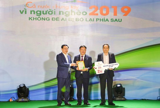 Chủ tịch Công đoàn Vietcombank trao tiền ủng hộ người nghèo của Vietcombank với sự chứng kiến của đồng chí Vương Đình Huệ - Ủy viên Bộ Chính trị, Phó Thủ tướng Chính phủ (nay là Bí thư Thành ủy Hà Nội) và đồng chí Trần Thanh Mẫn (bên phải) - Bí thư Trung ương Đảng, Chủ tịch UBTWMTTQ Việt Nam.