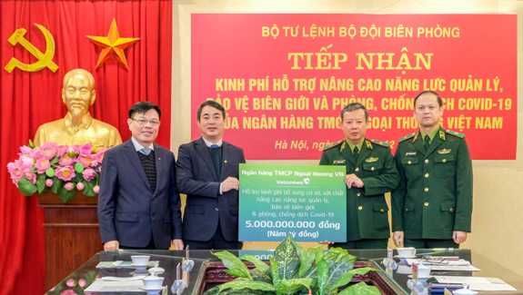 Đồng chí Nghiêm Xuân Thành - Bí thư Đảng ủy, Chủ tịch HĐQT Vietcombank và đại diện Công đoàn Vietcombank trao biển tượng trưng số tiền 5 tỉ đồng Vietcombank ủng hộ cho Bộ Tư lệnh Bộ đội biên phòng.