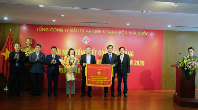 Đồng chí Hồ Sỹ Hùng -Phó Bí thư Ban cán sự đảng, Phó Chủ tịch Uỷ ban Quản lý vốn nhà nước tại doanh nghiệp trao Cờ thi đua Chính phủ đối với đơn vị xuất sắc trong phong trào thi đua năm 2019 cho Ban Lãnh đạo SCIC.