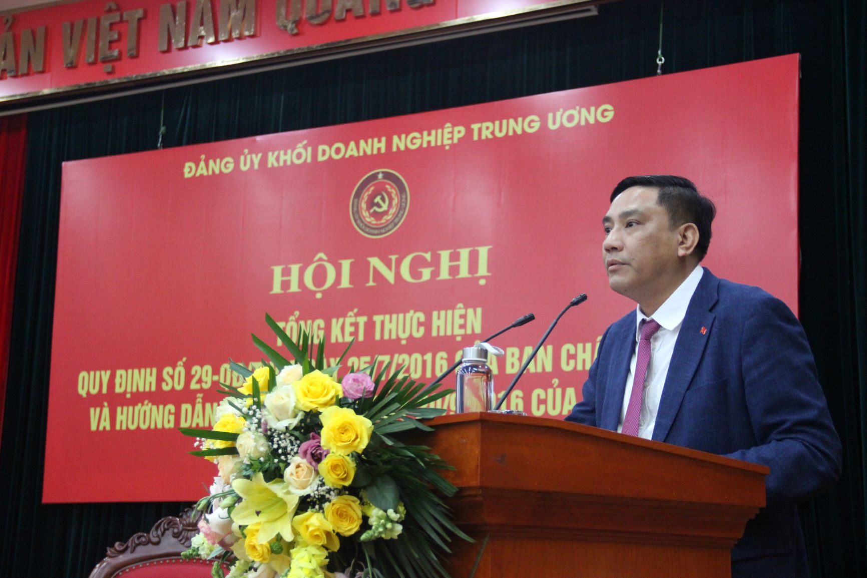 Đồng chí Hoàng Giang, Phó Bí thư Đảng ủy Khối trình bày tóm tắt báo cáo tổng kết của Đảng ủy Khối về việc thực hiện Quy định số 29-QĐ/TW và Hướng dẫn số 01-HD/TW về một số nội dung cụ thể thi hành Điều lệ Đảng.