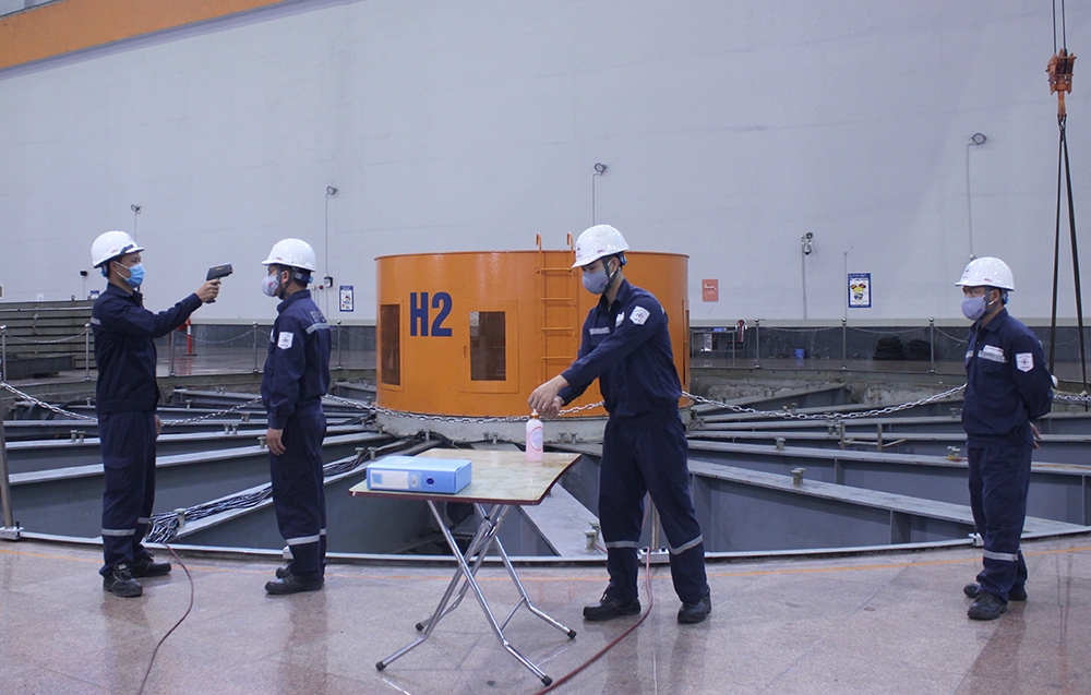 Công nhân kỹ thuật của EVNPSC thực hiện nghiêm ngặt các quy định phòng chống dịch COVID-19 khi thực hiện nhiệm vụ sửa chữa Tổ máy số 2  Nhà máy thủy điện Sơn La. 