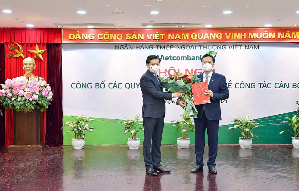 Đ/c Nguyễn Long Hải - Ủy viên dự khuyết BCH Trung ương Đảng, Bí thư Đảng ủy Khối Doanh nghiệp Trung ương trao Quyết định chuẩn y Bí thư Đảng ủy Ngân hàng TMCP Ngoại thương Việt Nam và tặng hoa chúc mừng đ/c Phạm Quang Dũng. 