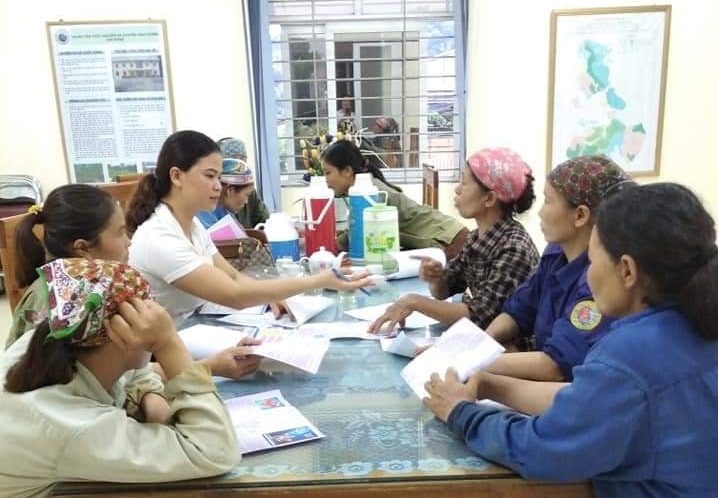 Chị Nguyễn Thị Phương đang tư vấn những lợi ích khi tham gia BHYT, BHXHTN với bà con huyện Ba Vì