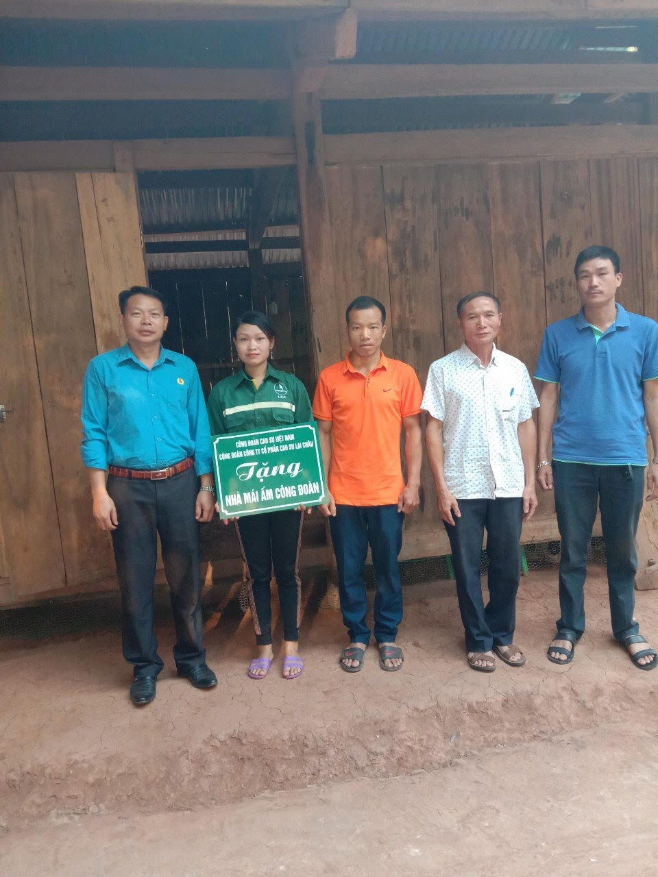 Anh Lò Văn Thương - Phó Bí thư Đảng bộ, Phó TGĐ, Chủ tịch Công đoàn Cao su Lai Châu (ngoài cùng bên trái) trao “Mái ấm Công đoàn” cho công nhân Nông trường Noong Hẻo.