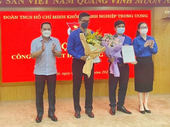 Đồng chí Hồ Xuân Trường - Phó Bí thư Đảng uỷ Khối DNTW tặng hoa chúc mừng và đồng chí Hoàng Thị Minh Thu - Bí thư Đoàn Khối DNTW trao Quyết định cho đồng chí Đỗ Khắc Dũng và đồng chí Nguyễn Văn Thuấn tại Hội nghị.