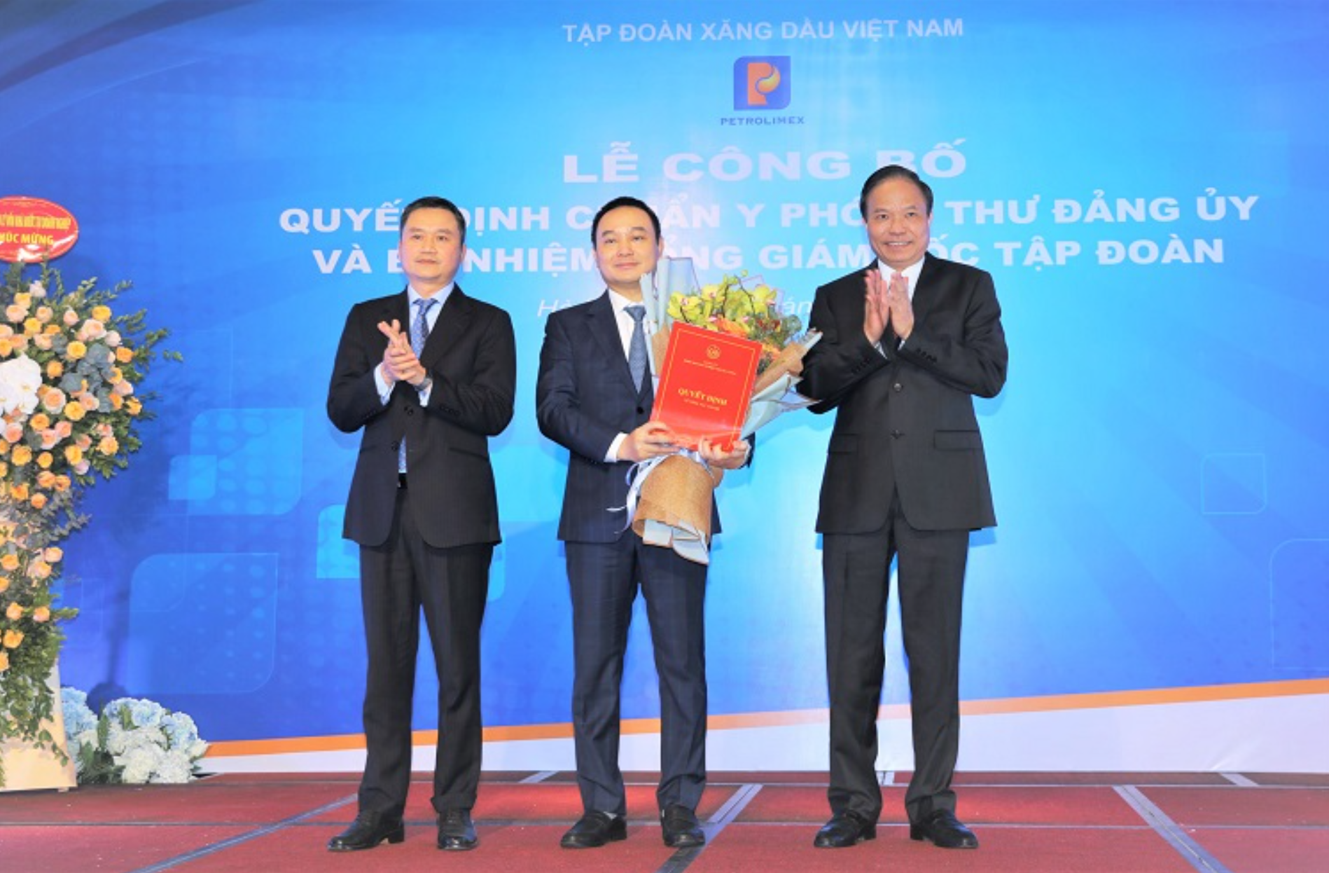 Phó Bí thư Đảng ủy Khối DNTW Lê Văn Châu và Bí thư Đảng ủy - Chủ tịch HĐQT Petrolimex Phạm Văn Thanh trao Quyết định và tặng hoa chúc mừng Phó Bí thư Đảng ủy Đào Nam Hải.