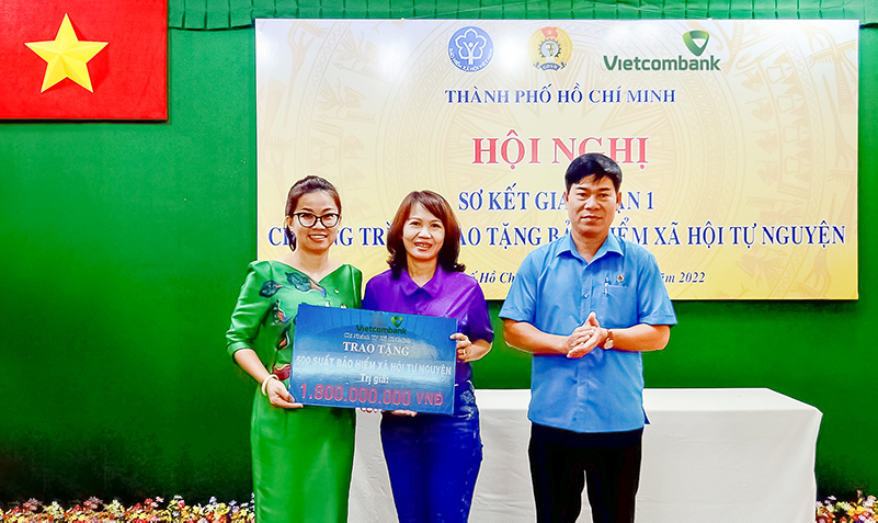 Bà Lê Thị Hòa Bình - Phó Giám đốc Vietcombank TP.HCM (bên trái) trao bảng tượng trưng tái tục BHXH trị giá 1,8 tỷ đồng cho đại diện đoàn viên các nghiệp đoàn nhận BHXH năm 2021