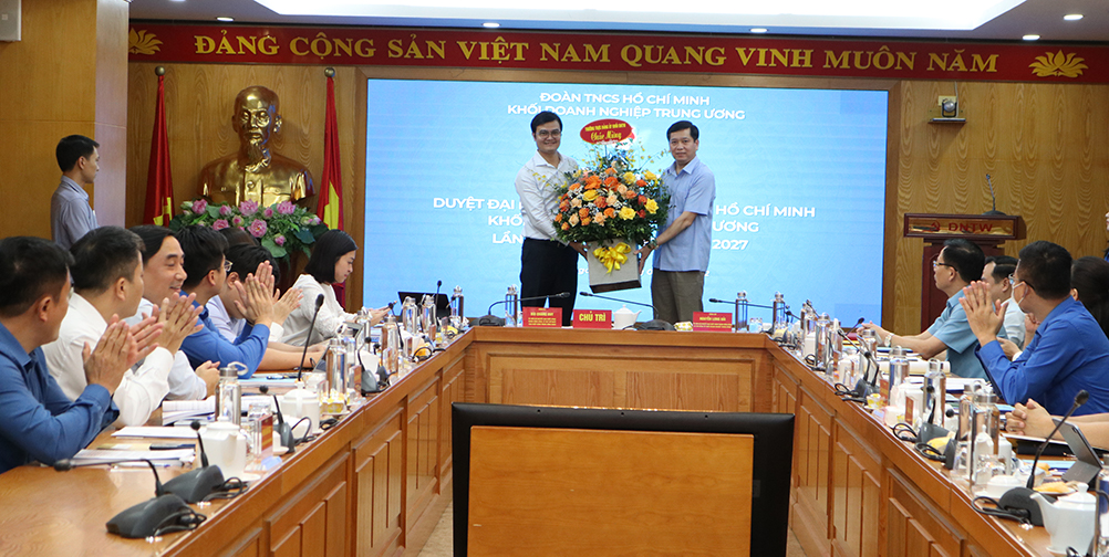 Đồng chí Nguyễn Long Hải - Bí thư Đảng ủy Khối Doanh nghiệp Trung ương tặng hoa chúc mừng đồng chí Bùi Quang Huy - tân Bí thư thứ Nhất Trung ương Đoàn.