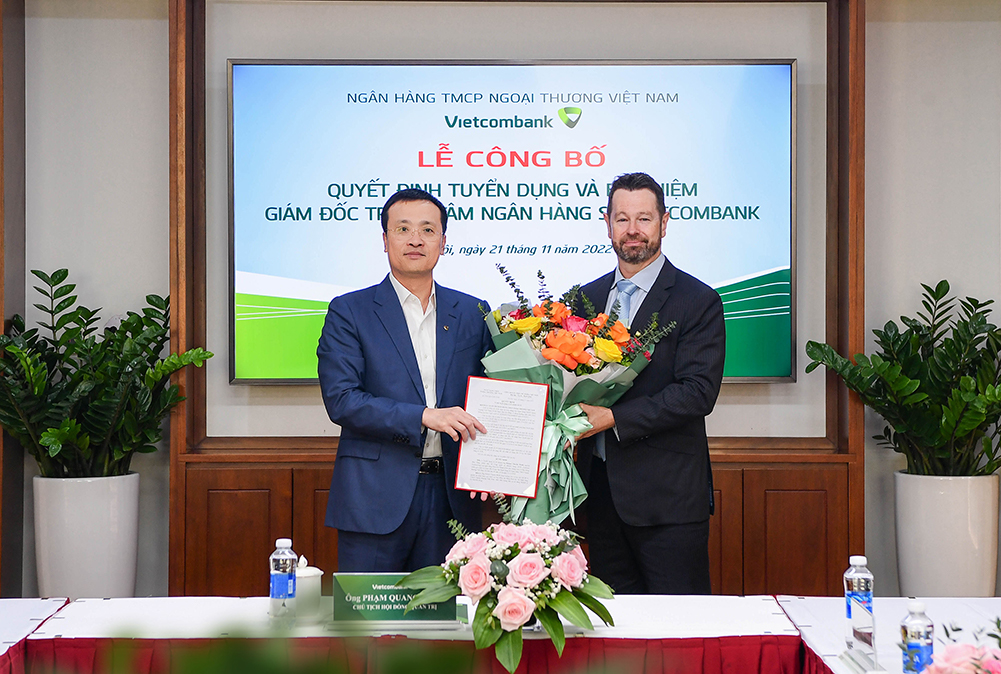 Bí thư Đảng ủy, Chủ tịch HĐQT Vietcombank (bên trái) Phạm Quang Dũng trao Quyết định và tặng hoa chúc mừng tân Giám đốc Trung tâm ngân hàng số Vietcombank.
