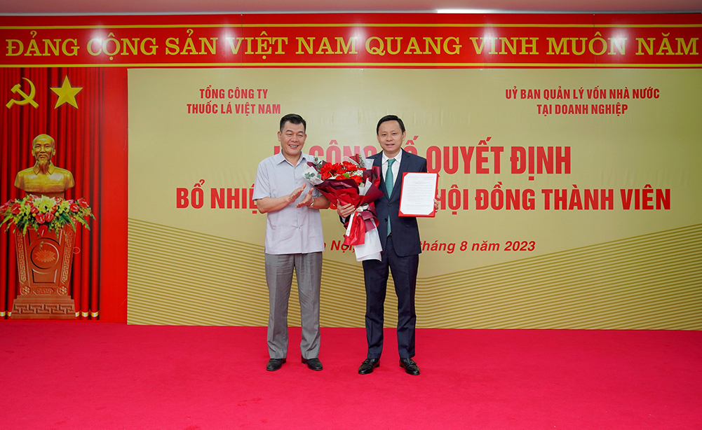 Nguyễn Đức Phong – Phó Bí thư thường trực Đảng ủy Khối DNTW lên tặng hoa chúc mừng đồng chí Hồ Lê Nghĩa. 