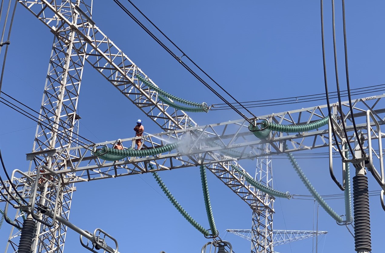  EVNNPT ứng dụng khoa học công nghệ trong quản lý vận hành. Trong ảnh Công nhân truyền tải điện vệ sinh sứ cách điện khi đang mang điện