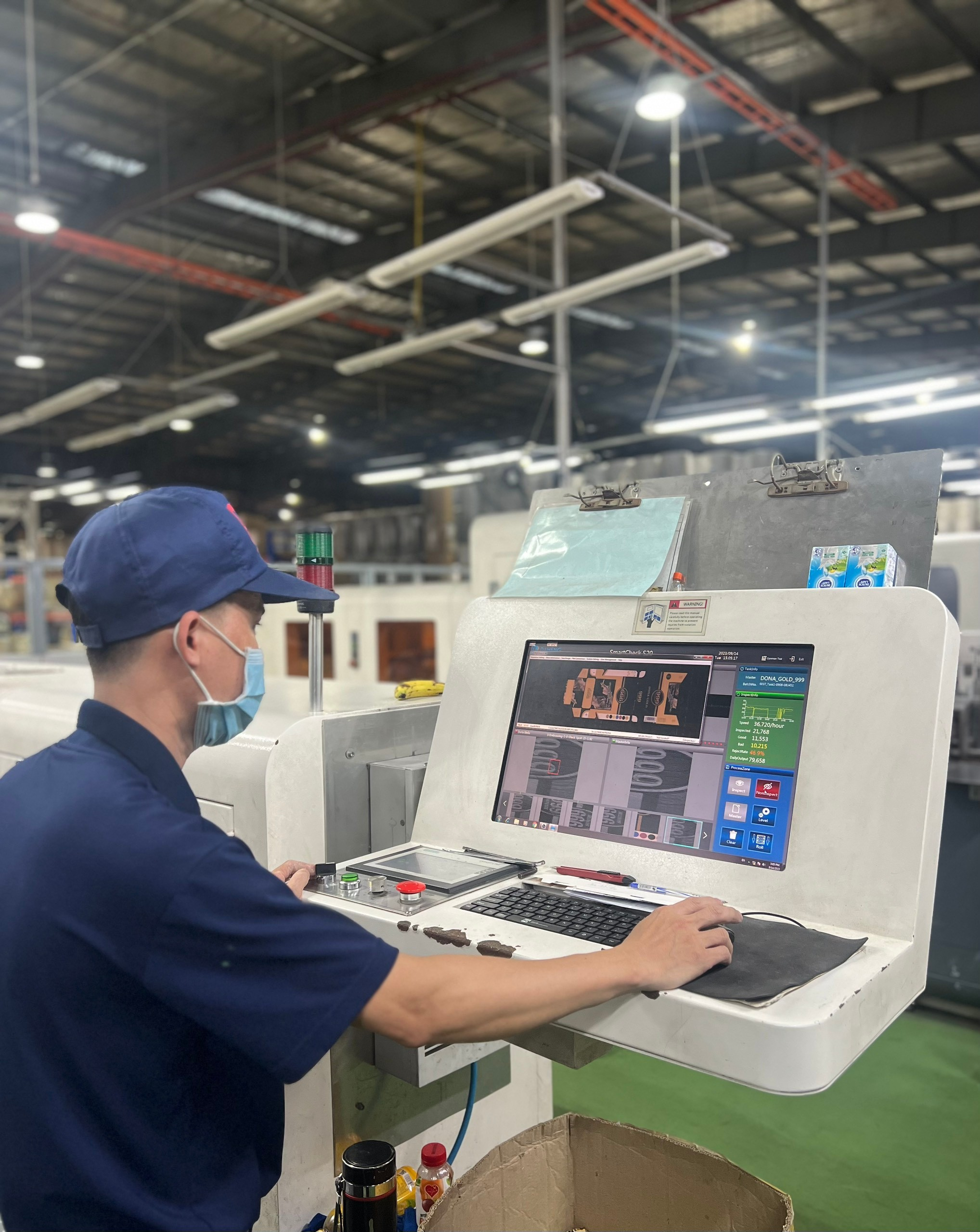 Nhân viên vận hành máy kiểm soát chất lượng sản phẩm trong quá trình sản xuất