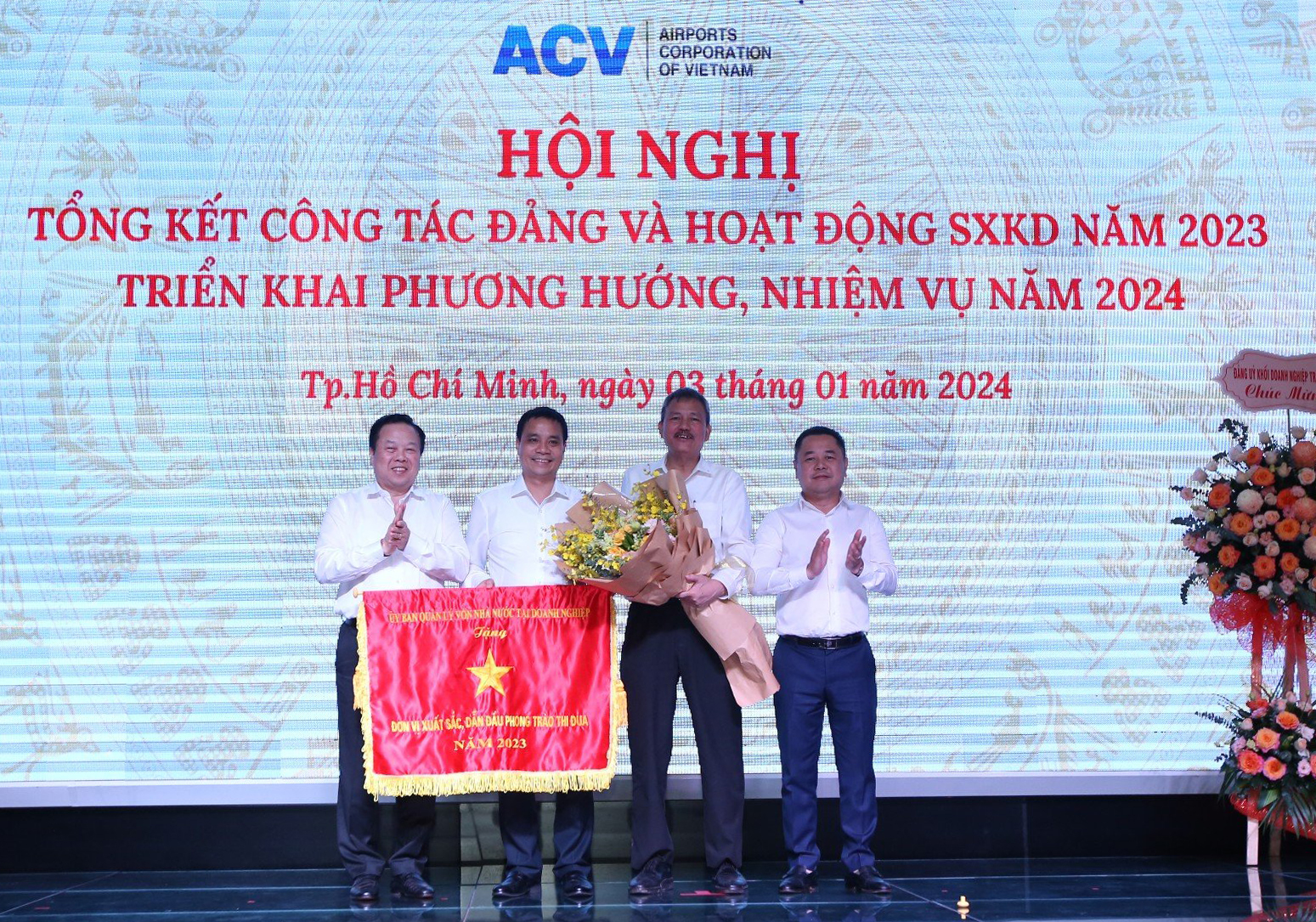 Đồng chí Nguyễn Hoàng Anh – Chủ tịch Ủy ban Quản lý vốn nhà nước tại doanh nghiệp và đồng chí Nguyễn Ngọc Cảnh – Phó Chủ tịch Ủy ban trao Cờ thi đua của Ủy ban và tặng hoa chúc mừng ACV vì thành tích là đơn vị xuất sắc, dẫn đầu phong trào thu đua năm 2023.